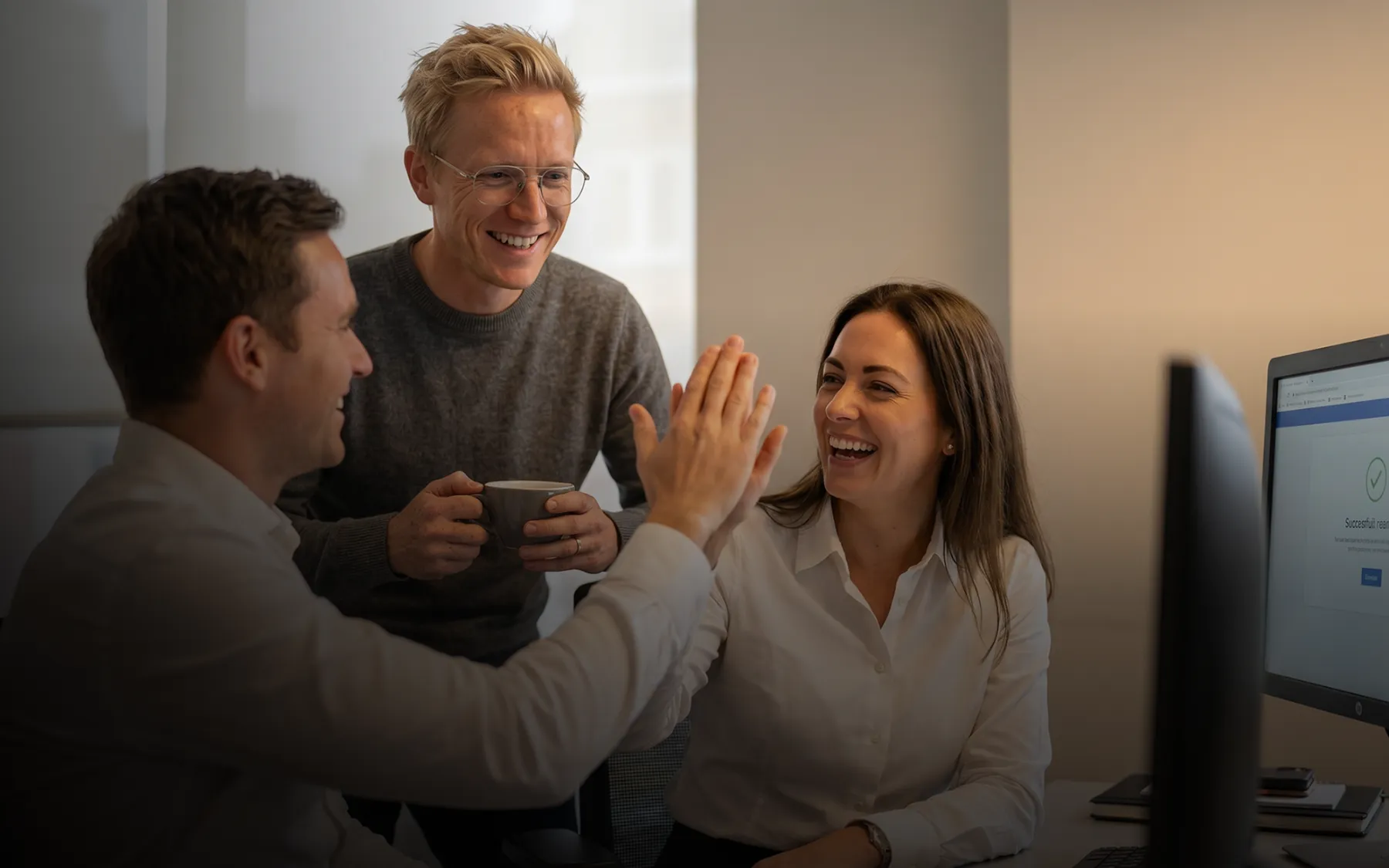 Team celebrating a result together in the office